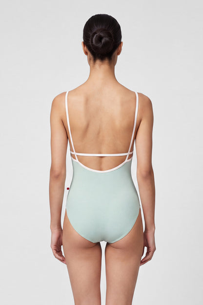 AI-generated model. Heather leotard, pale sage-grey with thin blush straps and neckline trim.