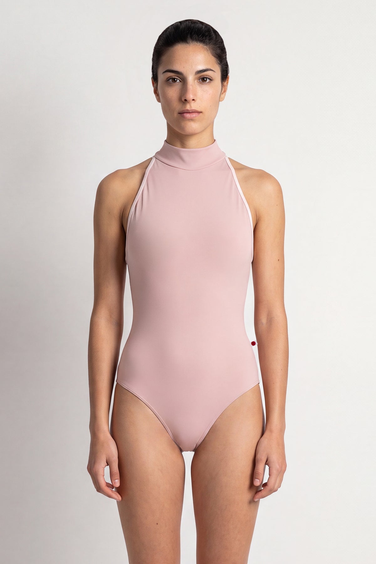 AI-generated model. Noe leotard, dusty-rose with a high halter neck and open sides.