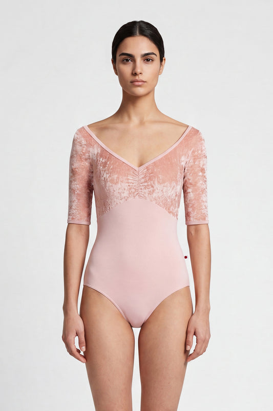 AI-generated model. Elli leotard, blush-pink with a crushed-velvet elbow-sleeve bodice and gathered V-neck.