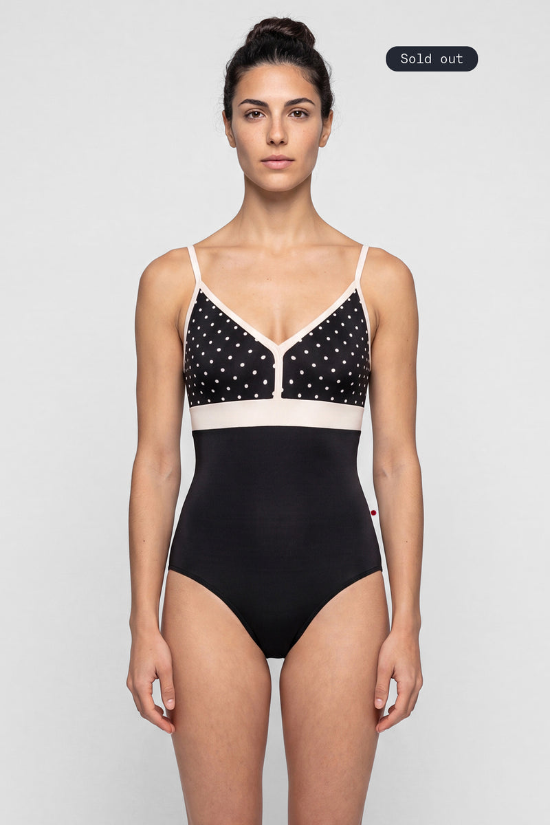 AI-generated model. Zoe leotard, black T-Lunares polka-dot V-neck bust with blush straps and waistband, black body.
